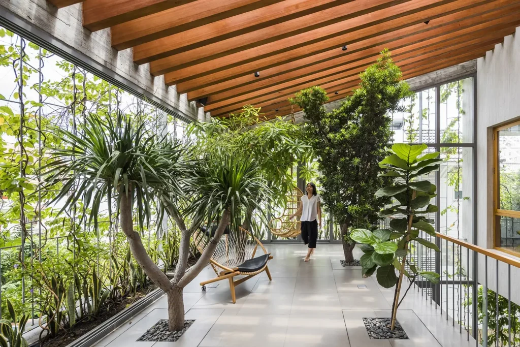 woman surrounded with plants and greenery in a building